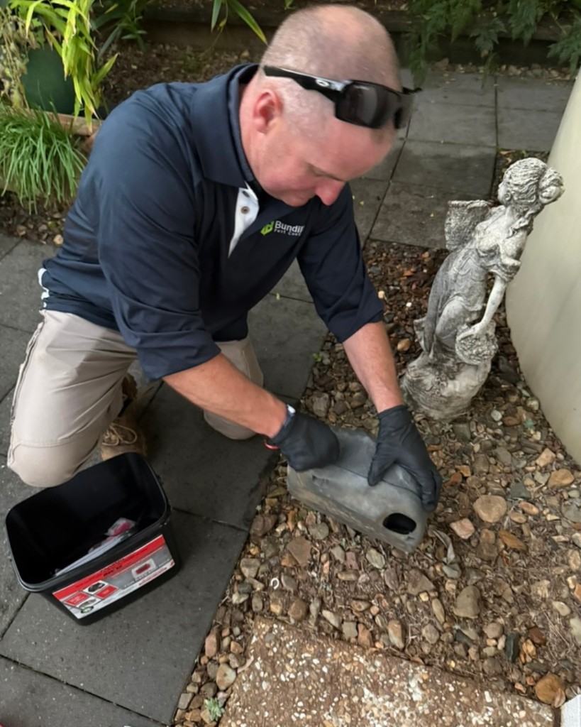 Technician inspecting a rodent bait station during on-the-job Ride & Learn training