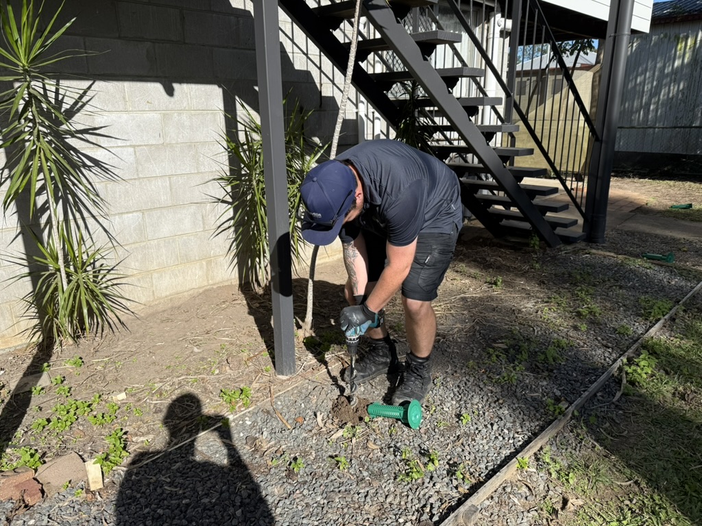 Technician installing a termite bait station during Ride & Learn training