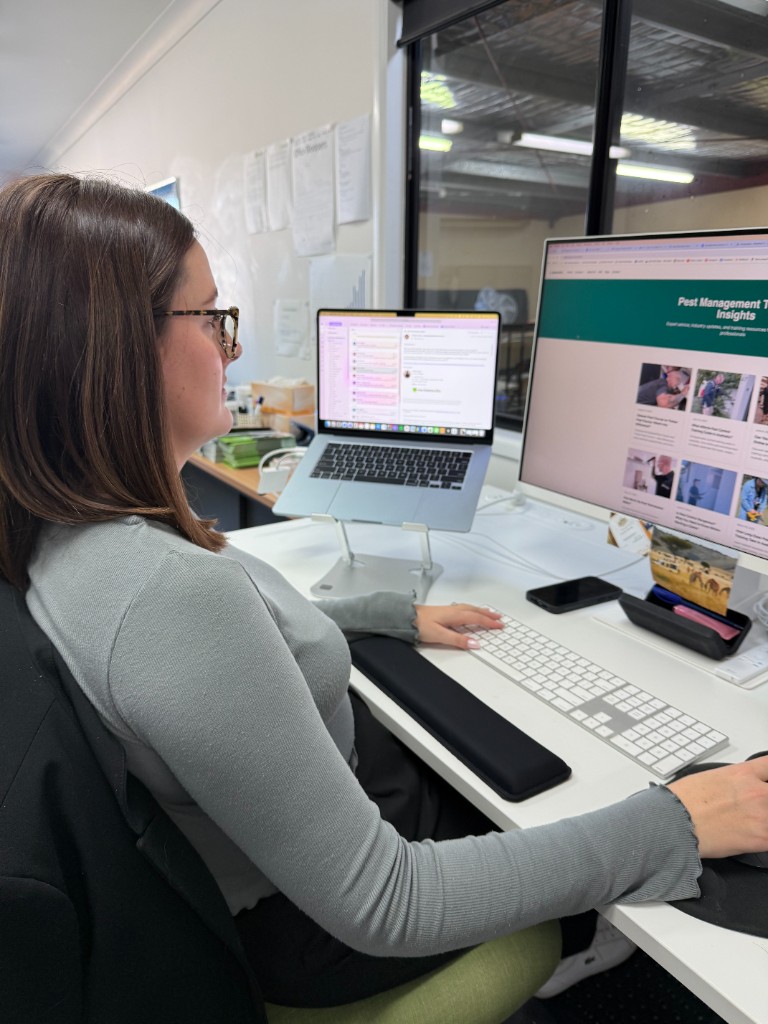 Sales and management staff member reviewing timber pest course materials at a desk