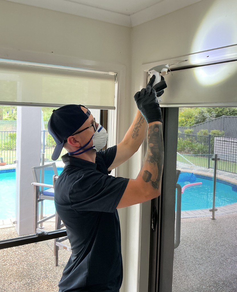 Pest control technician inspecting a sliding door during practical workplace training